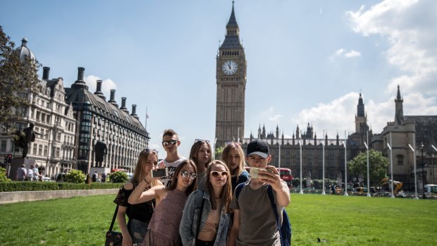Young tourists take a group selfie in Parliament Square.