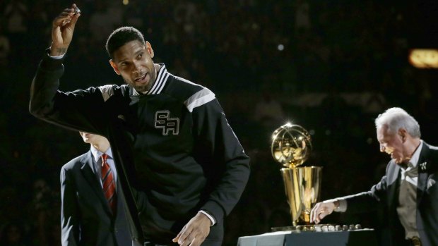 Champion five times over: Tim Duncan collects his ring at San Antonio's championship ceremony before their season opener against Dallas.