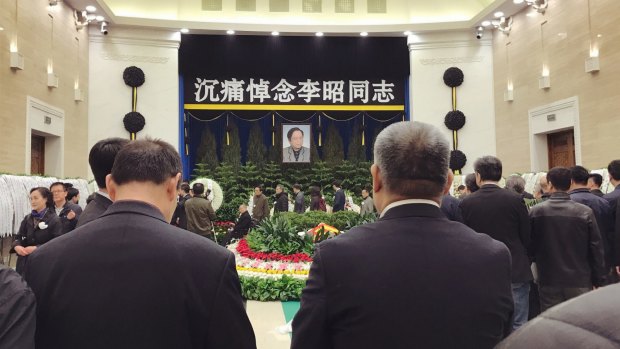 Wreaths from China's current top leaders lay on right of the Babaoshan Revolutionary Cemetary's mourning hall while family members of Li Zhao greet visitors on left. 