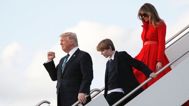 President Donald Trump with his wife first lady Melania Trump and their son Barron, pumps his fist as they disembark from Air Force One on Friday.