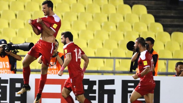 Key moment: Omar Al-Somah leaps for joy after his second half equaliser.