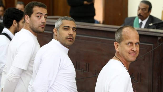 Mixed feelings about leaving his colleagues behind: Peter Greste (right) and co-defendants, Al-Jazeera English producer Baher Mohamed, left, Canadian-Egyptian acting Cairo bureau chief Mohamed Fahmy, centre.