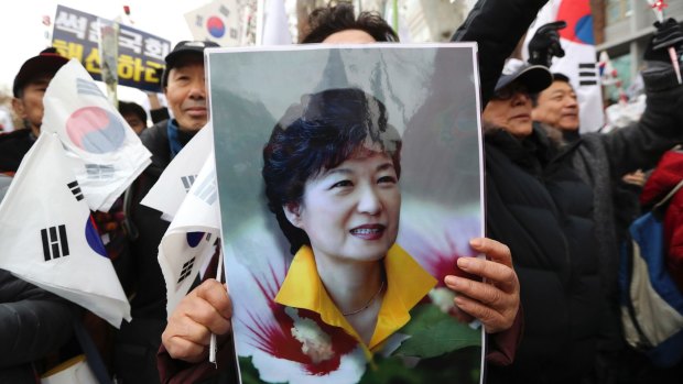 A supporter holds a portrait of South Korean President Park Geun-hye during a rally opposing her impeachment.