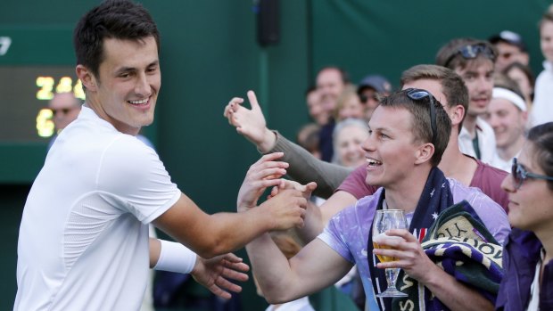Tomic celebrates with spectators after his victory on day six of Wimbledon.
