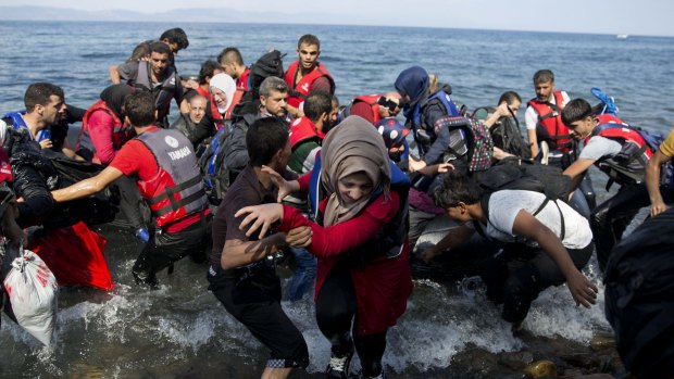 Migrants arrive on a dinghy after crossing from Turkey to Lesbos island, Greece.
