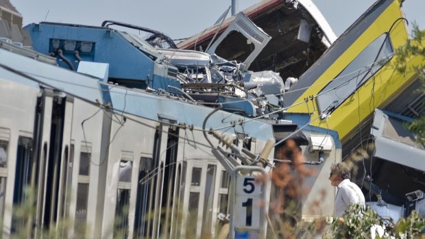 A man watches the scene of a train accident after two commuter trains collided head-on near the town of Andria, in the southern region of Puglia, killing several people, Tuesday, July 12, 2016.  (AP Photo/Gaetano Lo Porto)