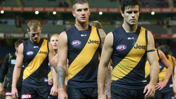 Dustin Martin and Trent Cotchin of the Tigers look dejected as they lead the team off the field after losing to Melbourne in round four.