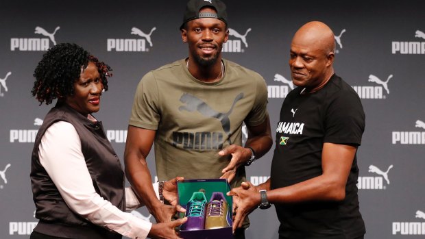 Usain Bolt with his parents, Jennifer and Wellesley, and the purple and gold shoes he will run in at the world titles.