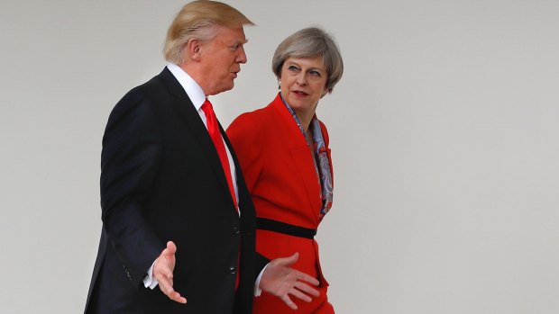 President Donald Trump and British Prime Minister Theresa May walk along the colonnades of the White House in Washington.