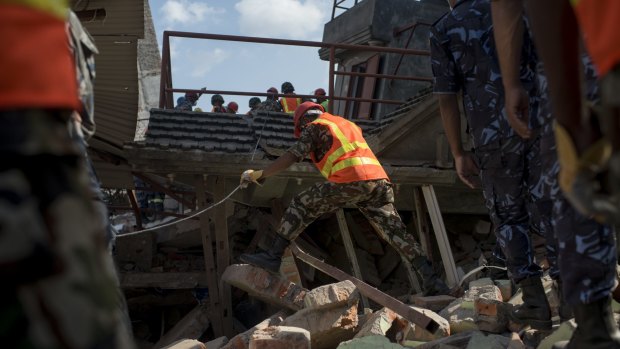 The Nepalese Army works to try to dig up a little boy believed to be in the rubble of a house that collapsed following a second major earthquake on May 12.