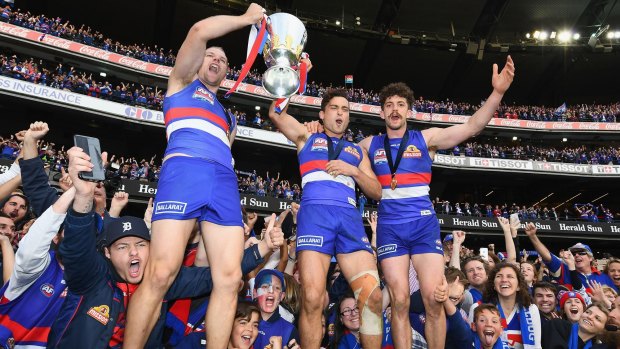 A win for the ages: Jake Stringer, Luke Dahlhaus and Tom Liberatore celebrates with the trophy.