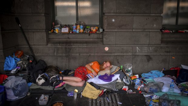 A homeless man with his accumulated belongings. 