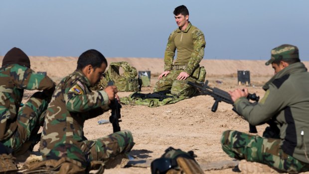 Australian soldier Corporal Emmette Taylor teaches Iraqi personnel how to strip an assault rifle at the Taji military complex.