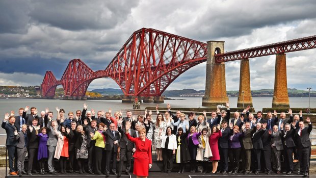 Scottish National Party leader Nicola Sturgeon (centre, in red) with the party's 56 Westminster MPs - up from 6 at the last election - in front of the Forth Bridge in South Queensferry, Scotland, on Saturday.