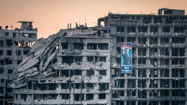 A poster of President Bashar al-Assad on a destroyed shopping mall in Homs, Syria.