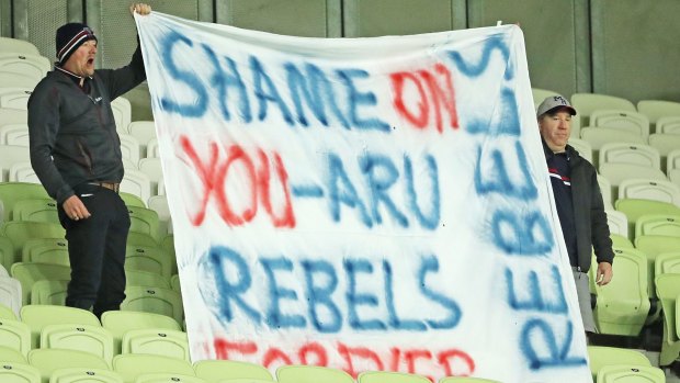 Rebels supporters in the crowd hold a sign and vent their anger at the ARU.