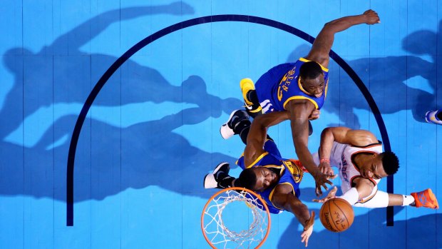 Under the bright lights: Oklahoma City star Russell Westbrook shoots against Draymond Green and Festus Ezeli in the Thunder's win over the Warriors.