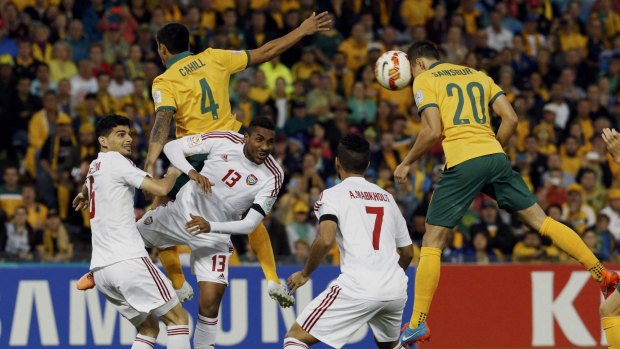 Trent Sainsbury (right) leaps high to head home Australia's first goal against the UAE at the Newcastle Stadium on Tuesday.