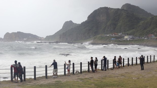 Visitors to a coastal park watch waves from approaching Typhoon Soudelor in Keelung.