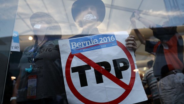 A Bernie Sanders supporter holds a sign opposing the Trans-Pacific Partnership as part of a sit-in at the Democratic convention's media tent.