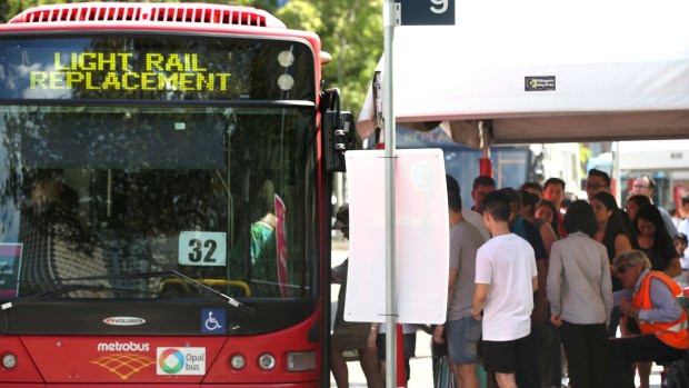 Commuters queue for replacement buses on Sunday due to track work on the light rail line. 