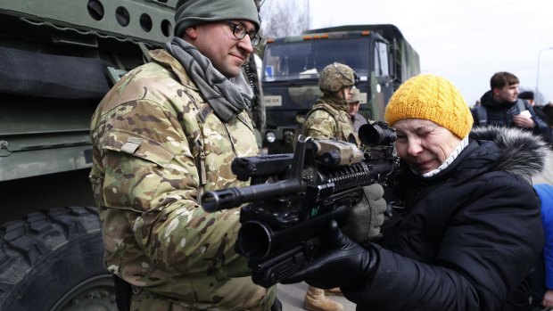 A US Army soldier shows a gun to a woman during the ''Dragoon Ride'' military exercise in Lithuania last year. The exercise was designed to reinforce America's allies, which include Poland.