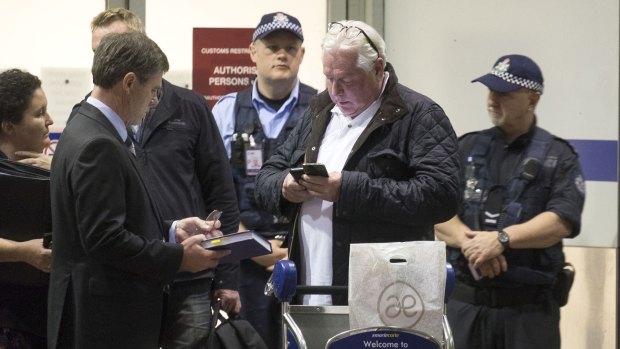 Andrew McManus being detained by police at Melbourne airport.