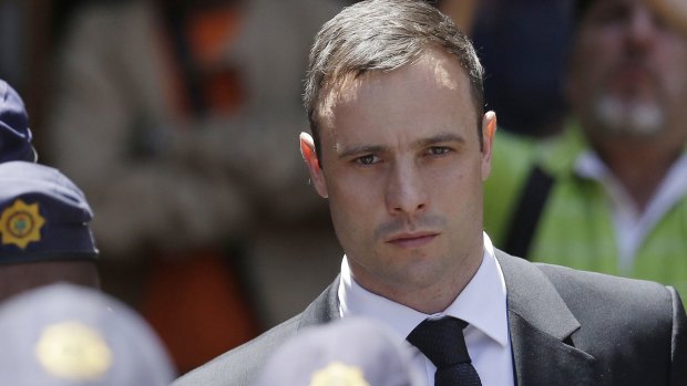 Oscar Pistorius is escorted by police officers as he leaves the high court in Pretoria, South Africa last year. 