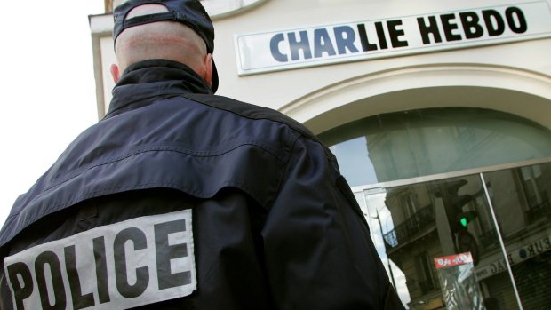 A policeman stands guard outside the French satirical weekly <i>Charlie Hebdo</i> in Paris in this February 9, 2006 file photo. The magazine has been targeted by Islamists before.