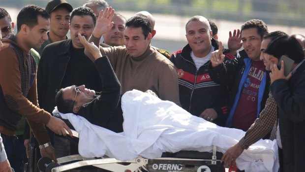 Former Egyptian president Hosni Mubarak leaves a helicopter ambulance last year.