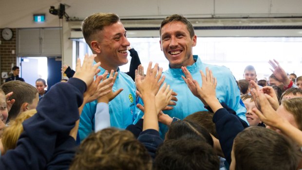 Happy in the middlie: Socceroos star Mark Milligan (right) visiting children at Double Bay Public School on Wednesday.