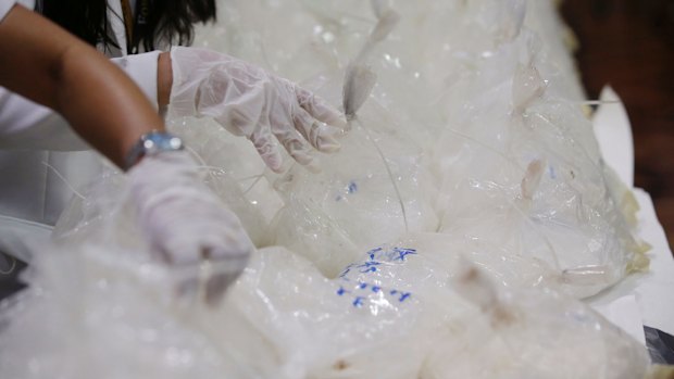 Members of the National Bureau of Investigation arrange packs of seized methamphetamine in Manila on Monday.