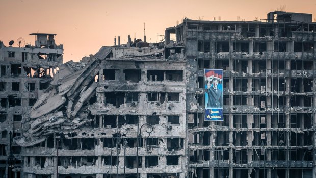 A poster of President Bashar al-Assad on a destroyed shopping mall in Homs, Syria.