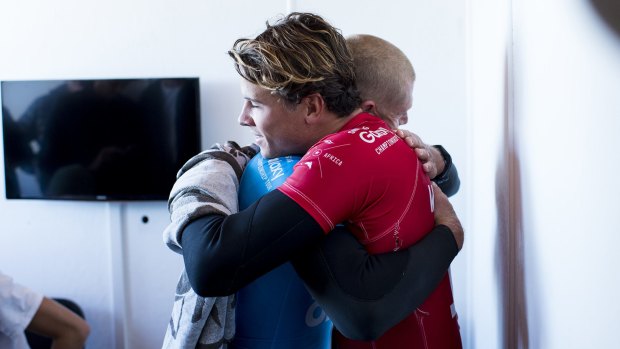 Julian Wilson (in red) hugs Mick Fanning, who was attacked by a shark during the fInal of the J-Bay Open on Sunday.