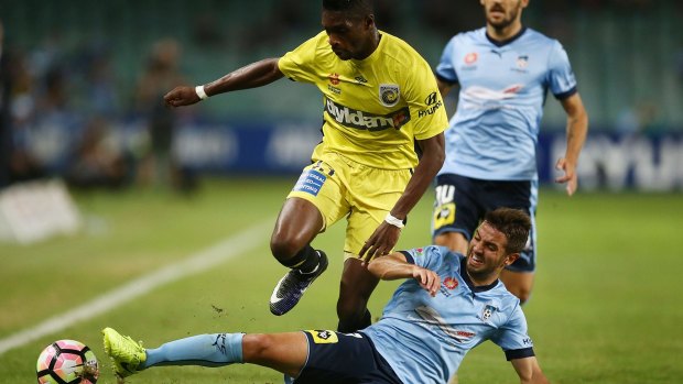 Substandard: Kwabena Appiah of the Mariners is tackled by Michael Zullo on the torn-up pitch at Allianz Stadium.