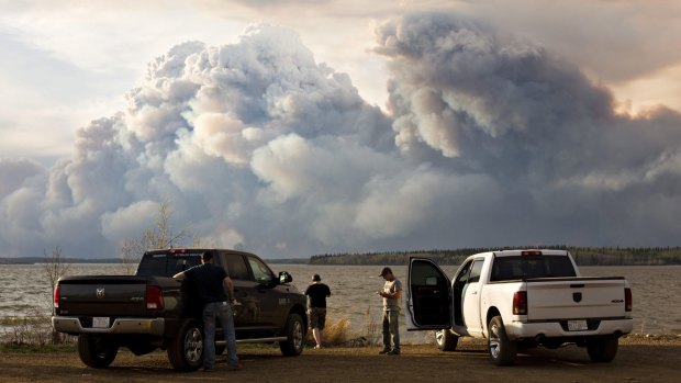 Evacuees watch the wildfire near Fort McMurray, Alberta, on Wednesday.