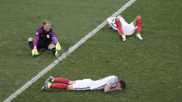 Down and out: England goalkeeper Joe Hart (left) and teammates lie on the pitch in despair after losing to Iceland.