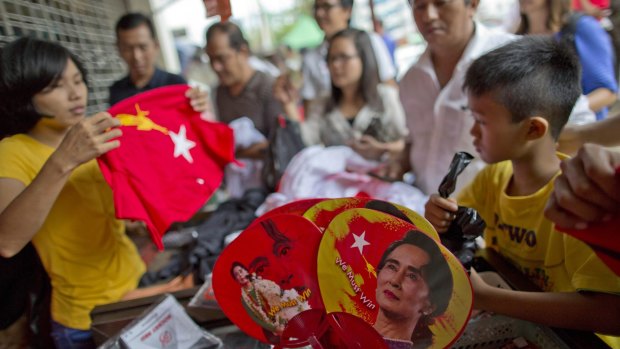 People buy merchandise with pictures of Aung San Suu Kyi at a shop run by her National League of Democracy in Yangon.