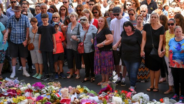 Mourners gather at the makeshift memorial for the Bourke Street tragedy.