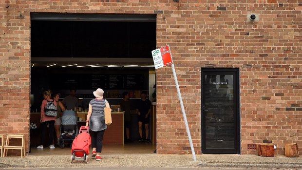 A woman walks into The Carpenter, a cafe in Leichhardt, Sydney. 