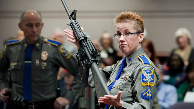 Firearms training unit Detective Barbara Mattson, of the Connecticut State Police, holds up a Bushmaster AR-15 rifle, the same make and model of gun used by Adam Lanza in the Sandy Hook School shooting, in a file picture.