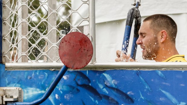 Jack Gunston tales a dip in a dunking machine at the Hawks' family day on Sunday.