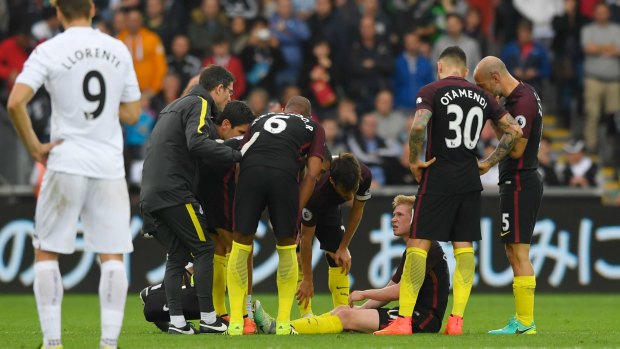 The Manchester City team check on Kevin de Bruyne.