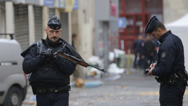 Lockdown: Police officers guard the street of the raid in Saint-Denis, Paris, on Thursday.