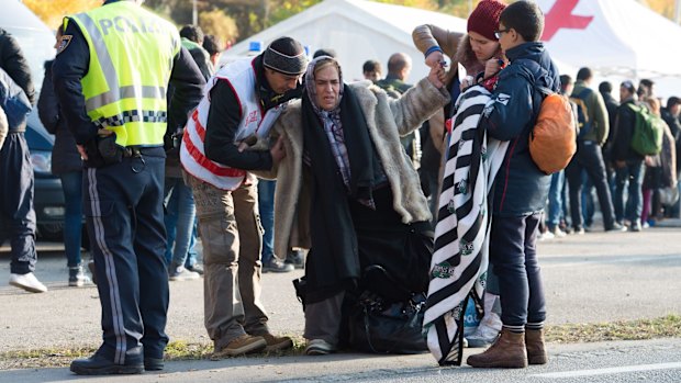 A Red Cross worker helps a Syrian family after crossing the border between Austria and Germany near Passau last month. 