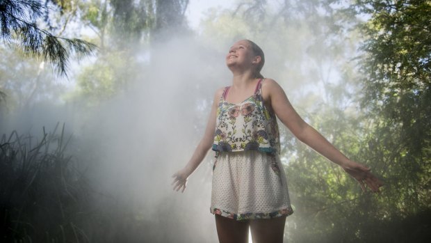 Rosie Hyett of Melbourne cools off in the Fujiko Nakaya Fog sculpture at the National Gallery of Australia.