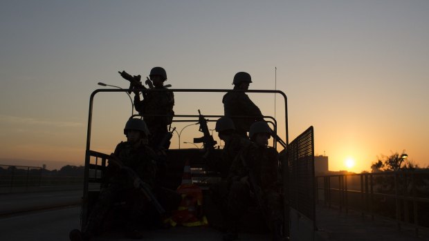 Soldiers patrol on a highway near the Mare Complex slums at sunrise in Rio de Janeiro, on Sunday.