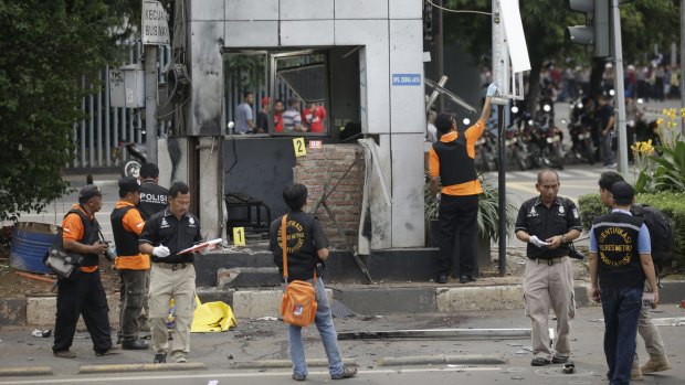 Police officers examine a police post where one of the explosions went off. 