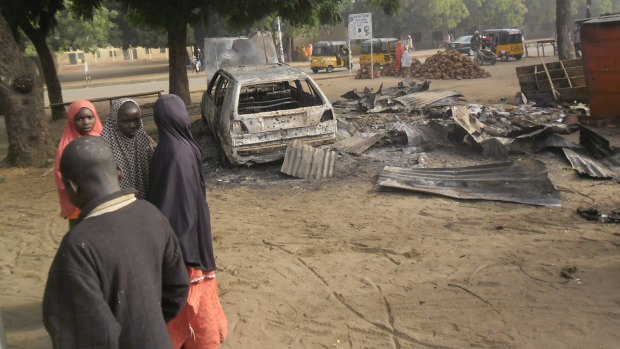 Children stand near the scene of a suicide bomb attack in Potiskum.