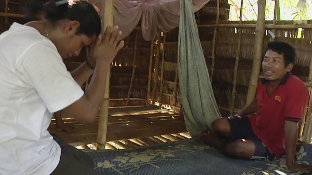 Former slave fisherman Kyaw Naing, left, pays respects after he is reunited with his brother Kyaw Oo at his home in Myaung Mya, Myanmar. 